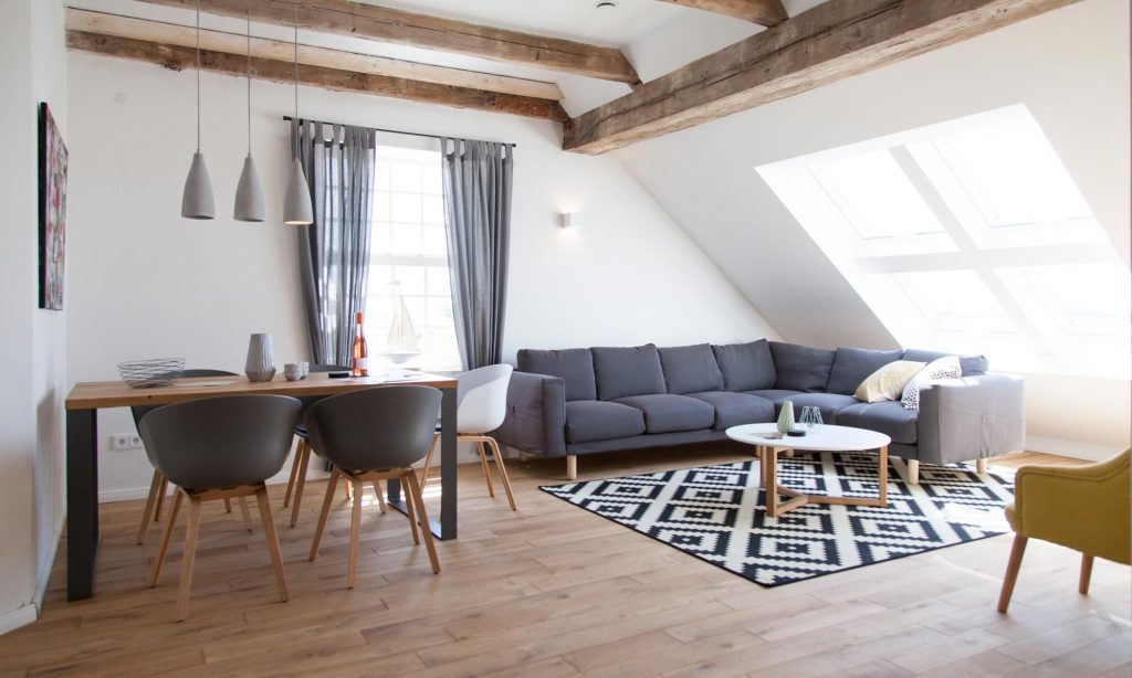 Offener Wohn- and Essbereich der Ferienwohnung Ine mit Dachfenstern and alten Holzbalken