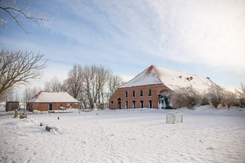 Der Gulfhof Polder72 im Schnee mit Backhaus und verschneitem Innenhof