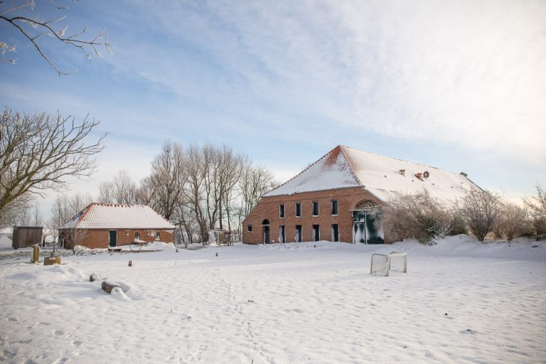 Der Gulfhof Polder72 im Schnee mit Backhaus und verschneitem Innenhof