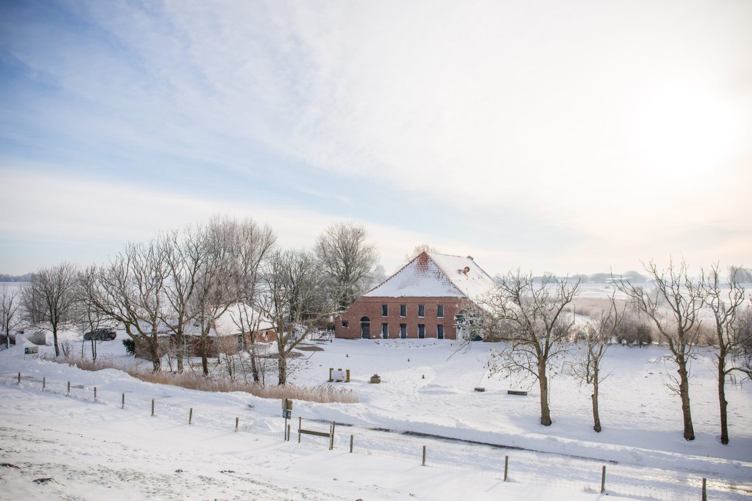 Blick vom Deich auf den verschneiten Gulfhof Polder72